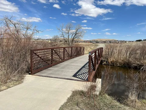 The footbridge where the paved Coal Creek Trail crosses the creek, bare cottonwoods on the far bank