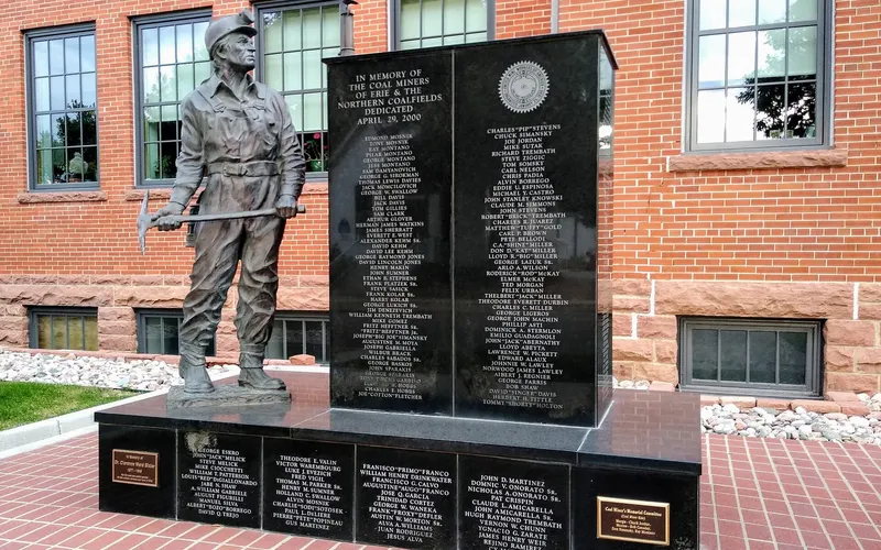 The bronze coal miner of the Erie Coal Miners' Memorial, with the names of more than 500 miners on black granite behind him