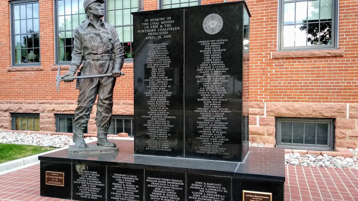 The bronze coal miner of the Erie Coal Miners' Memorial, with the names of more than 500 miners on black granite behind him